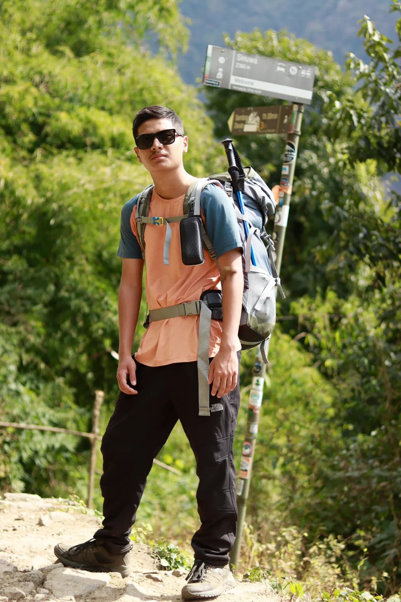 Sworup Shrestha smiling beside a mountain trail